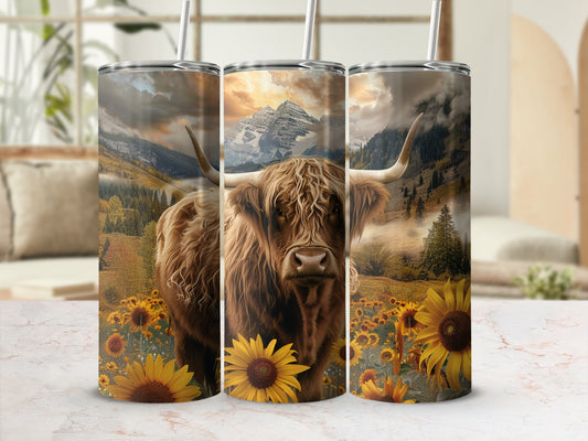 Tumbler with highland cow in sunflower field with mountains.