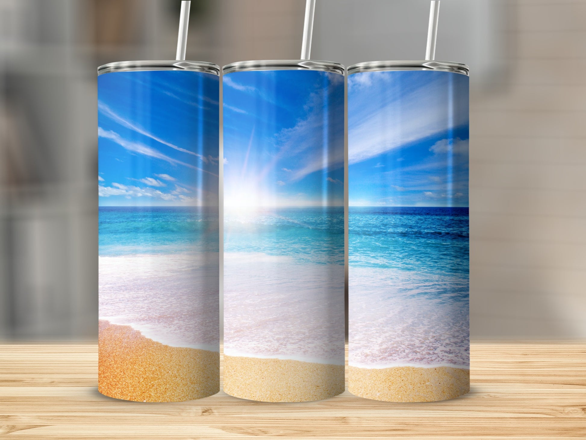 Three tumblers with a beach scene, featuring sand, ocean, and sky.