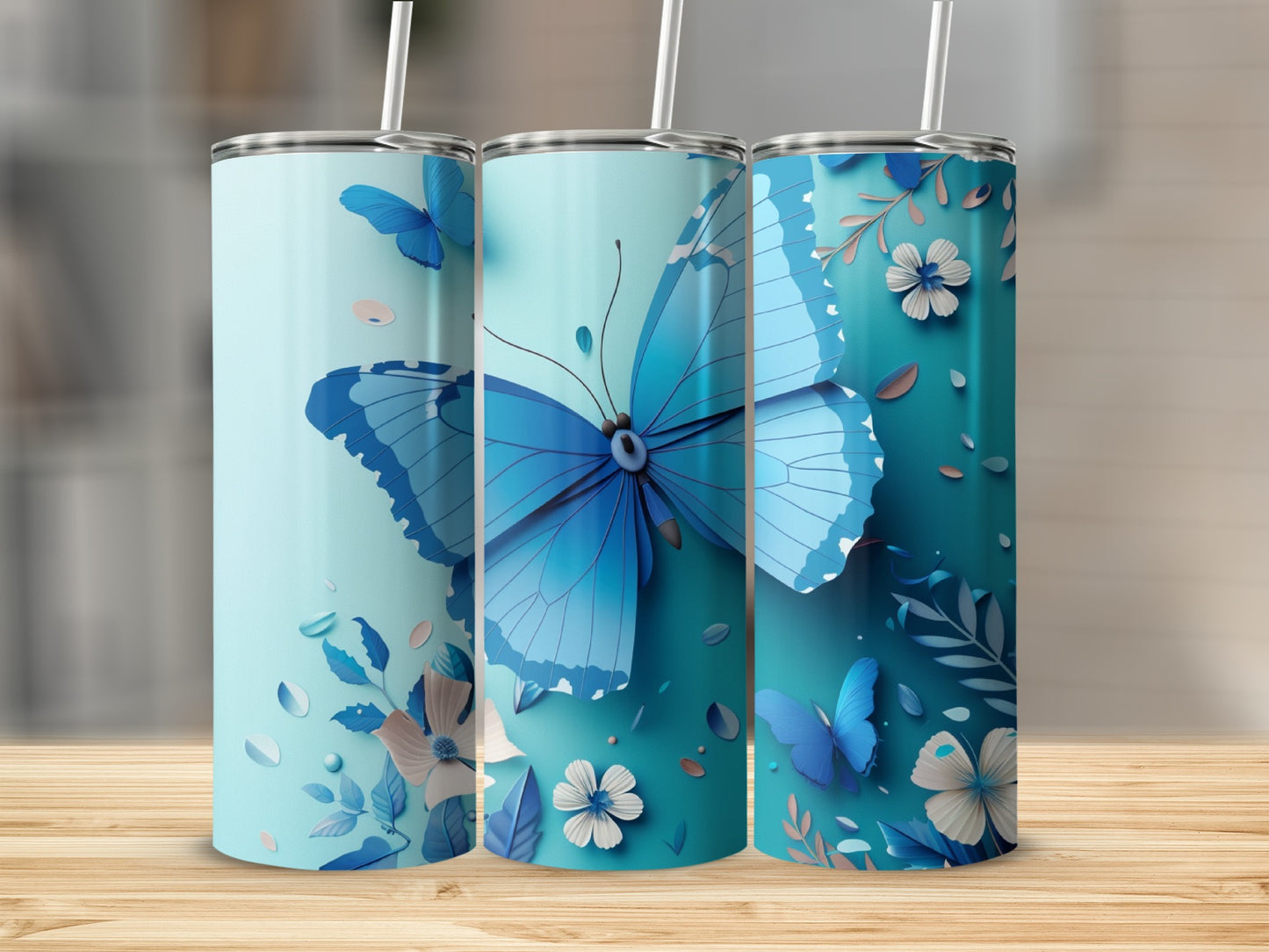 Three blue tumblers with butterfly and floral designs.