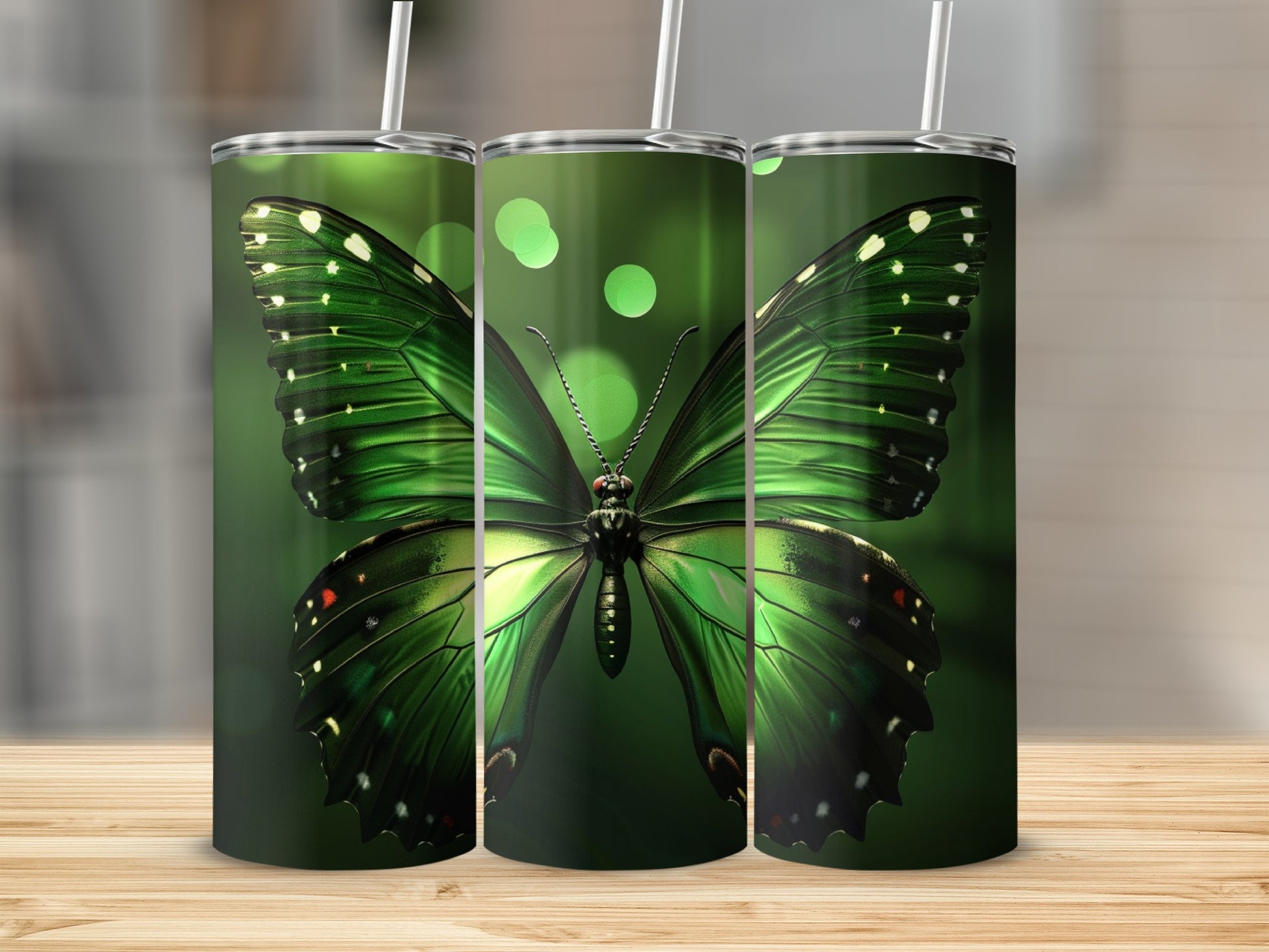 Three green butterfly tumblers with straws on a wooden surface.