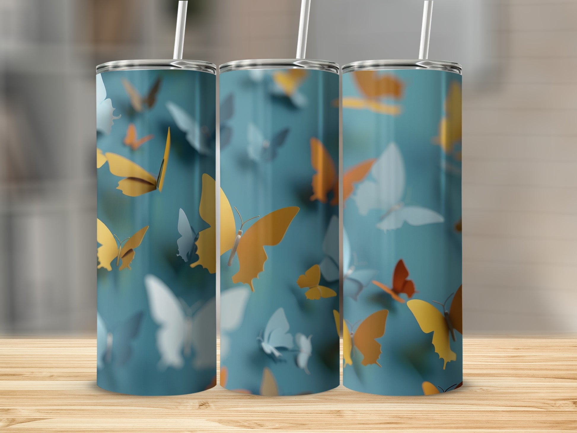 Three tumblers with colorful butterflies on a teal background.