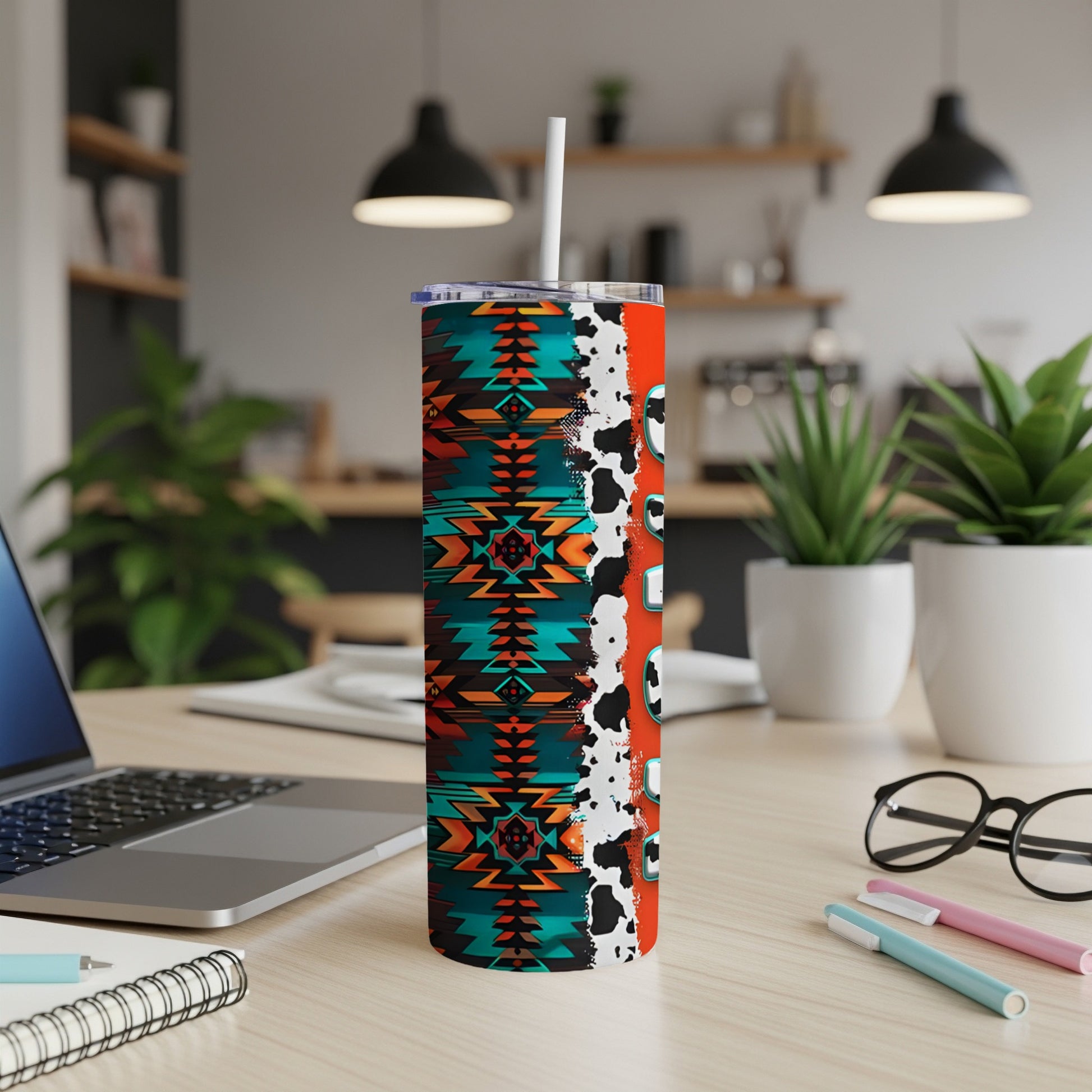 Tribal patterned tumbler with cow print and colorful accents on desk.