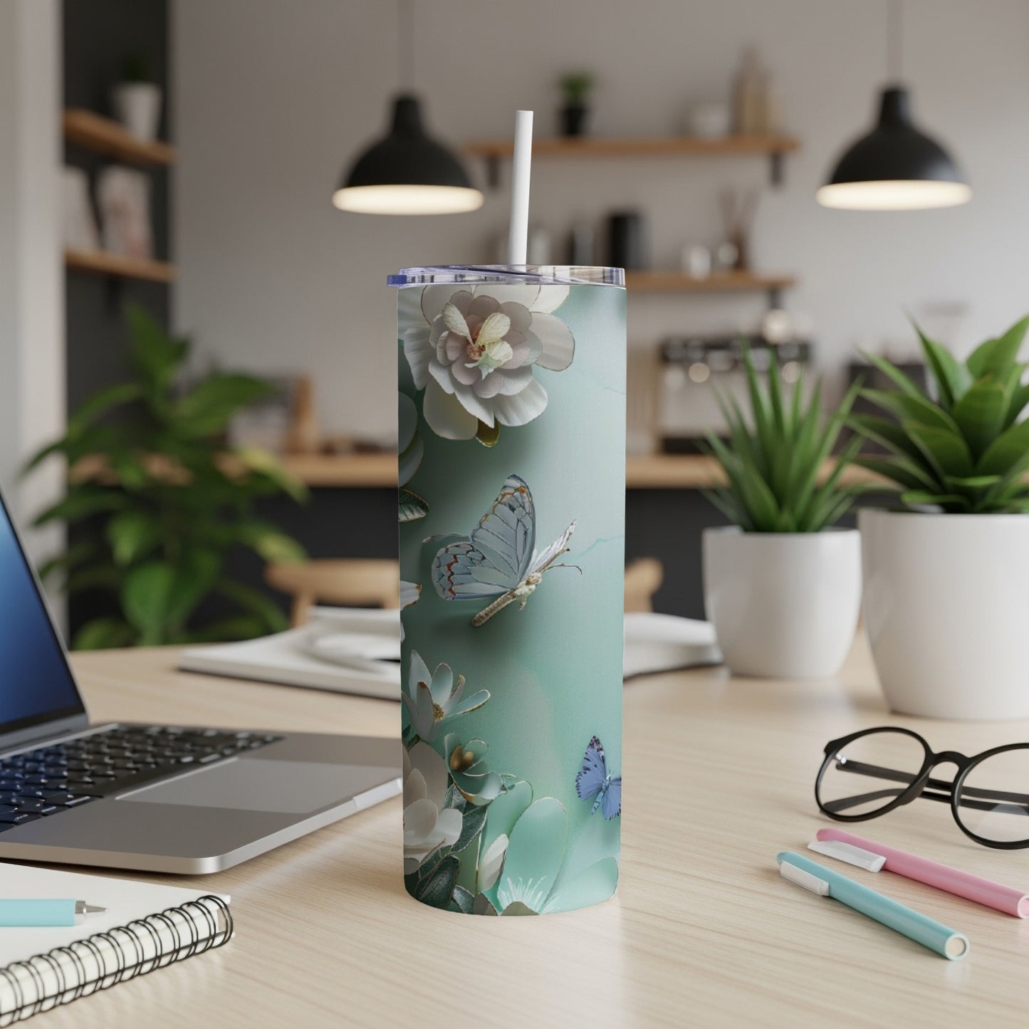 Mint green tumbler with white floral and butterfly design, white straw.