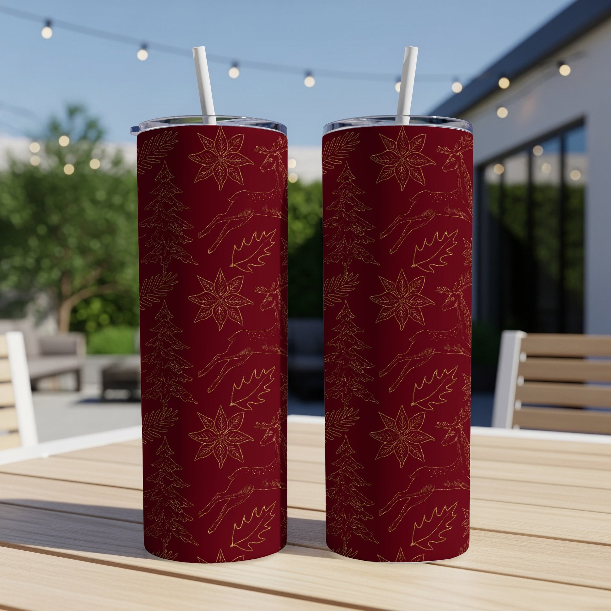 Two dark red tumblers with gold deer, pine trees, and holly leaf pattern.