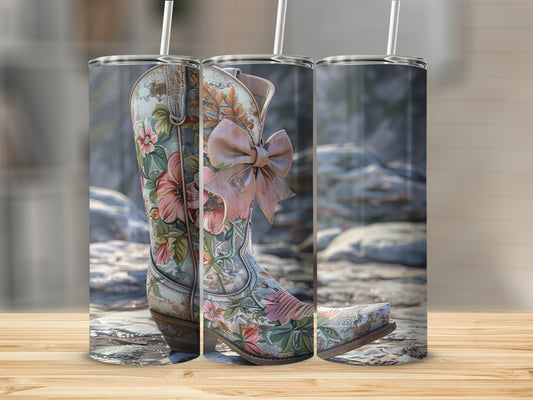 Cowboy boot with floral pattern and pink bow on a wooden surface.