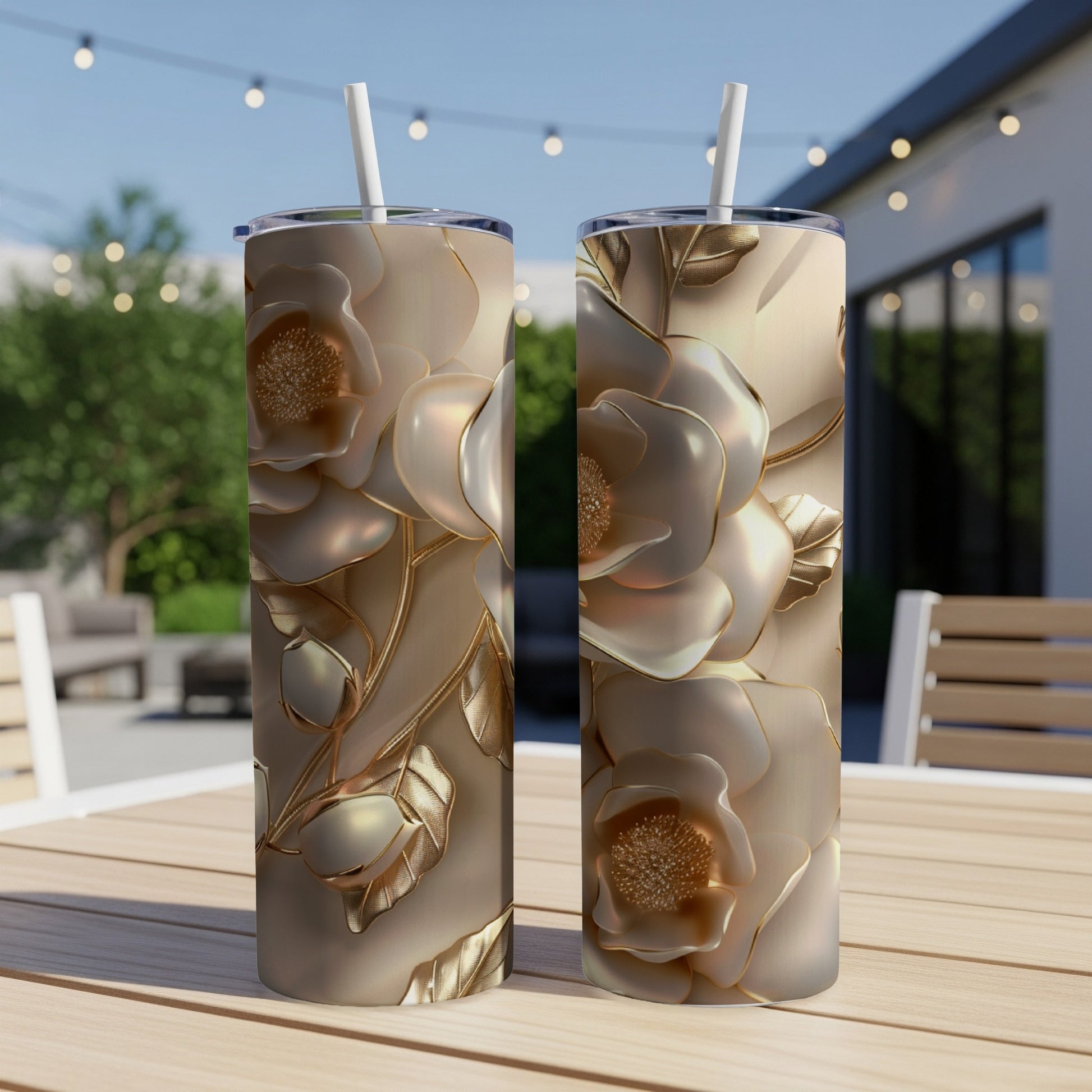 Two tall tumblers with embossed golden flowers and leaves on a wooden table.