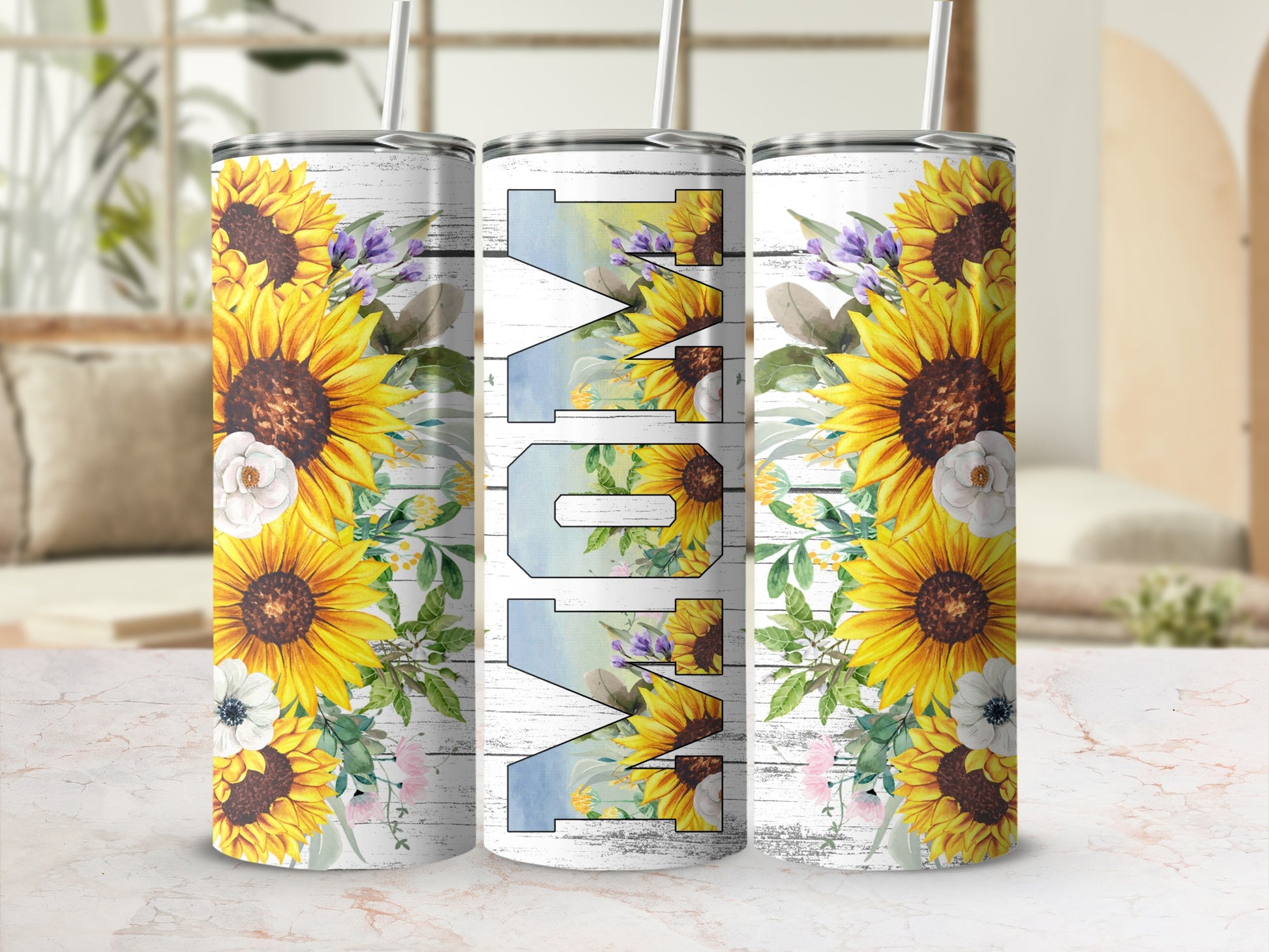 Three tumblers with sunflowers and "Mom" text against a light, textured background.