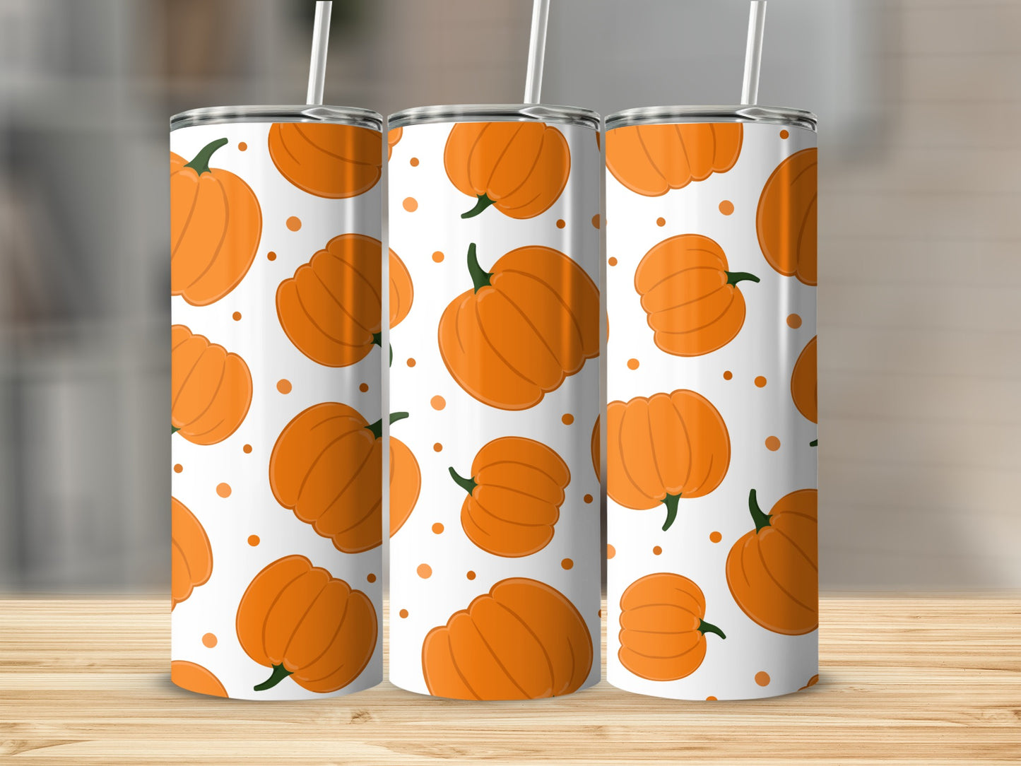 Three tumblers with a repeating pumpkin pattern and white straws.