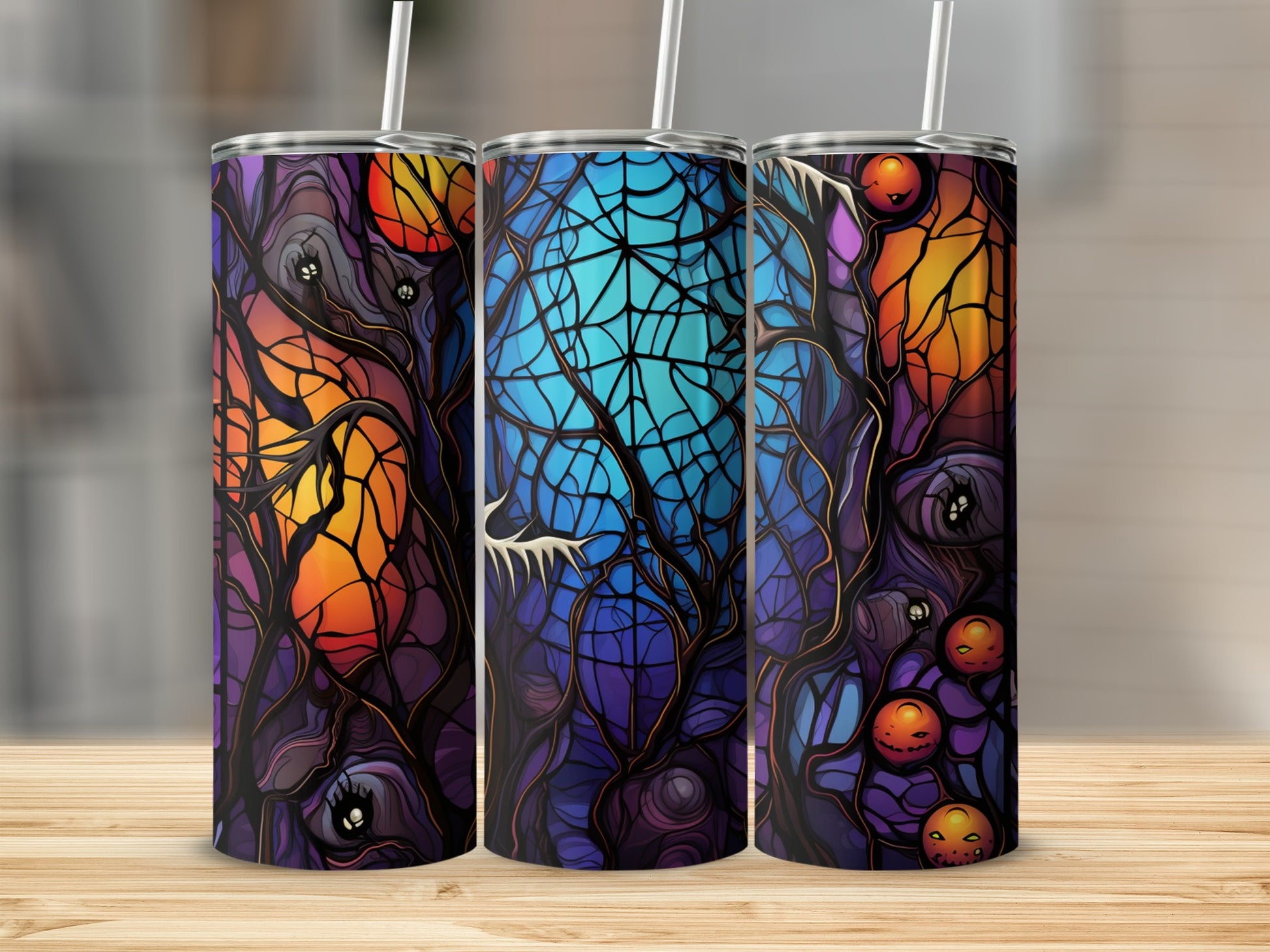 Three Halloween-themed tumblers with stained-glass style spooky trees and pumpkins.