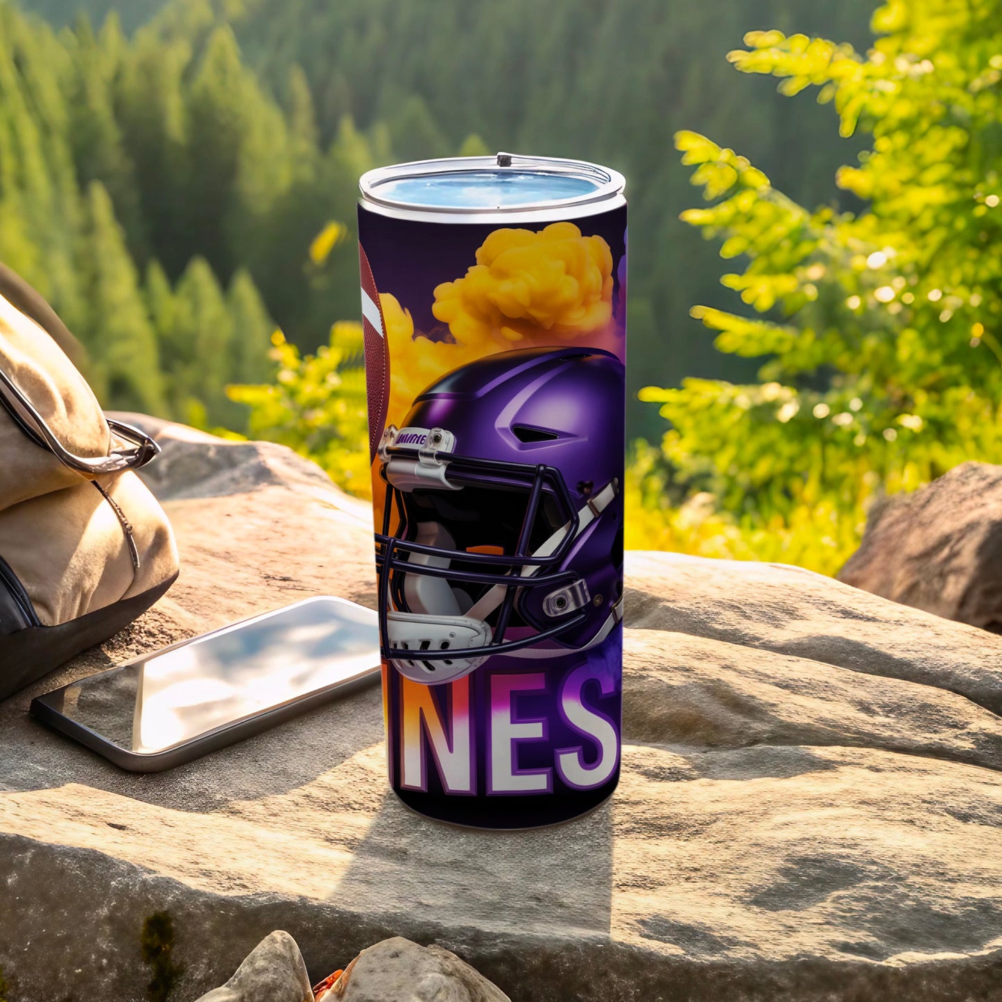 Purple football helmet with "INES" text on a tumbler, outdoors.