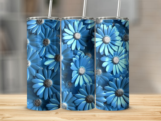 Three blue floral print tumblers with straws on a wooden surface.