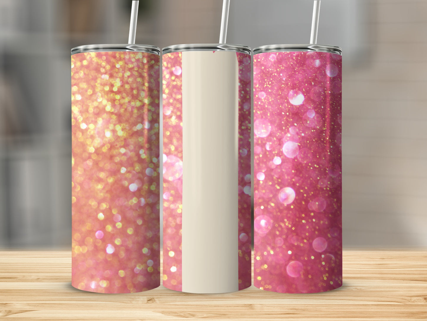Three pink glitter tumblers with straws on a wooden surface.