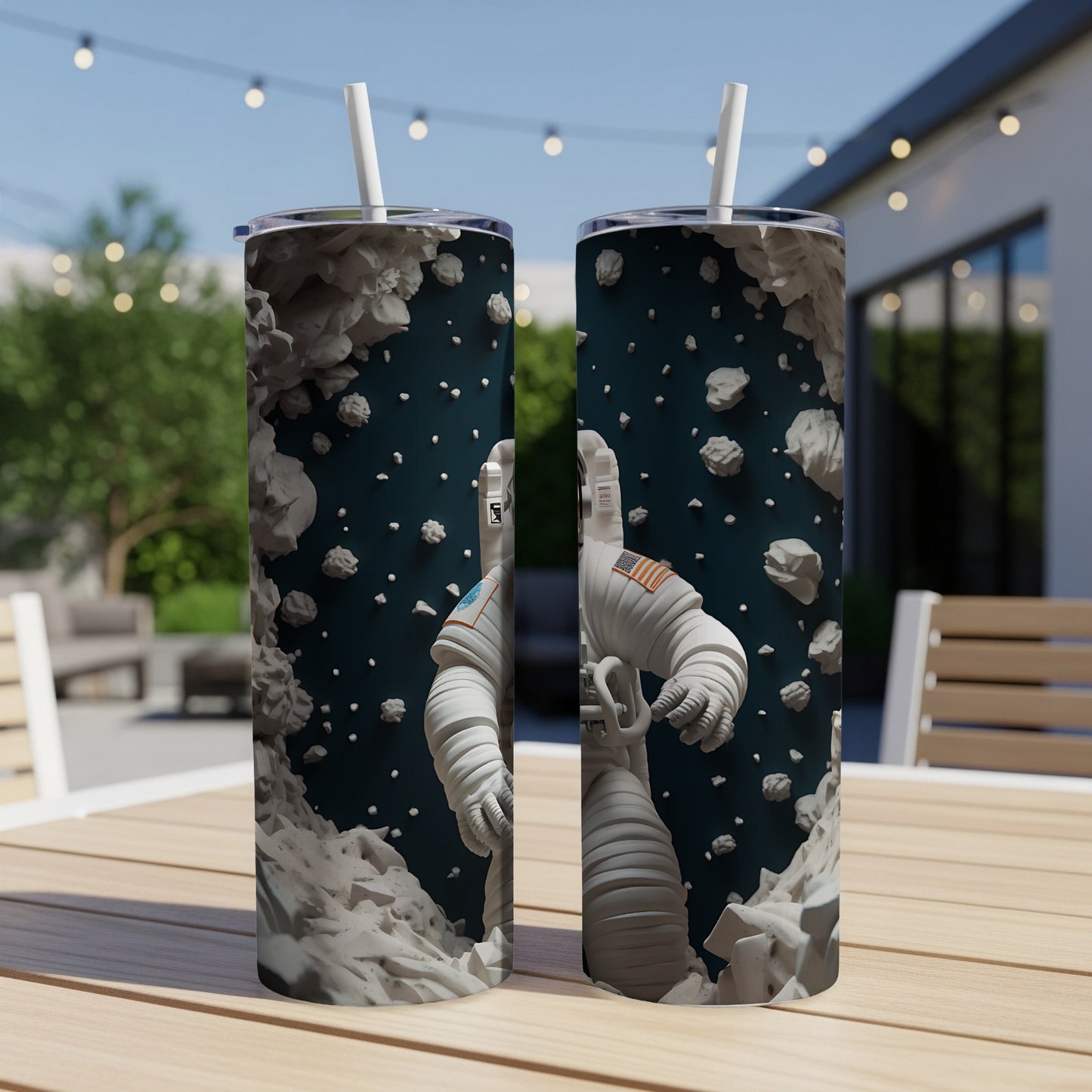 Astronaut graphic on two tumblers with straws, surrounded by asteroids.