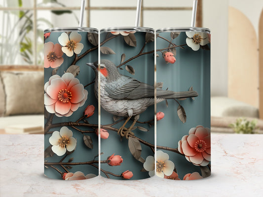 Tapered tumbler with a gray bird perched on a branch with pink and white flowers.