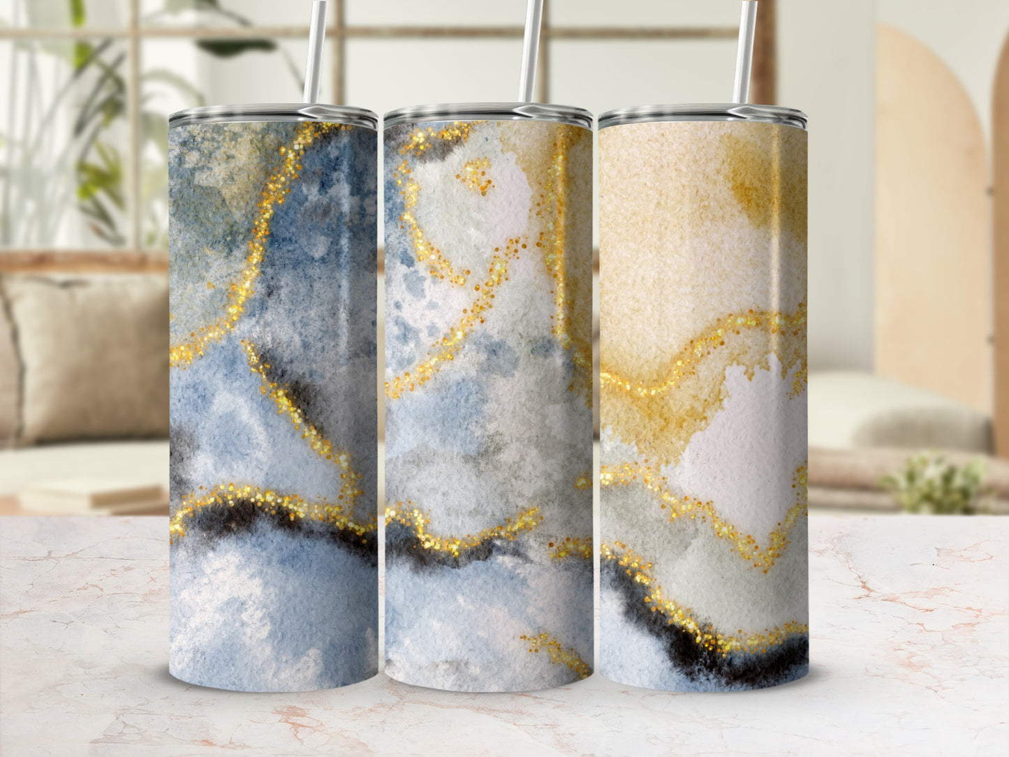 Three tumblers with blue and gold watercolor and glitter abstract design.