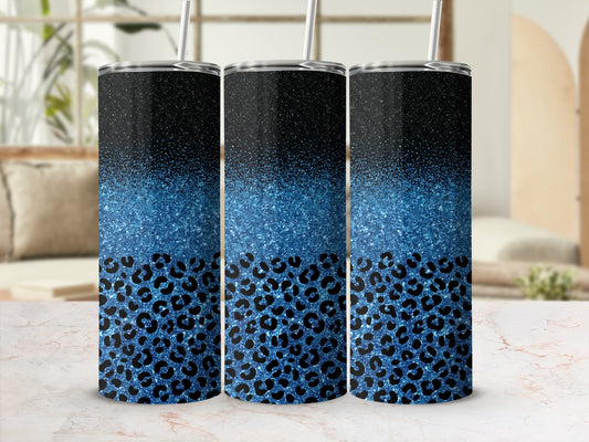 Three glitter and leopard print tumblers with straws on a counter.