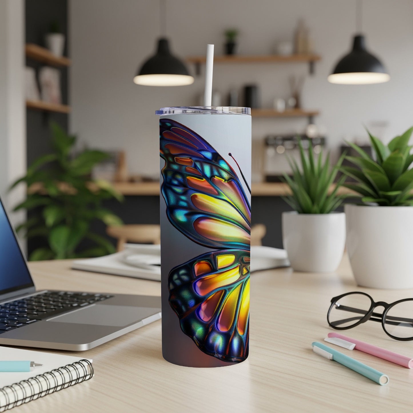 Tall tumbler with a colorful iridescent butterfly design, sitting on a desk.