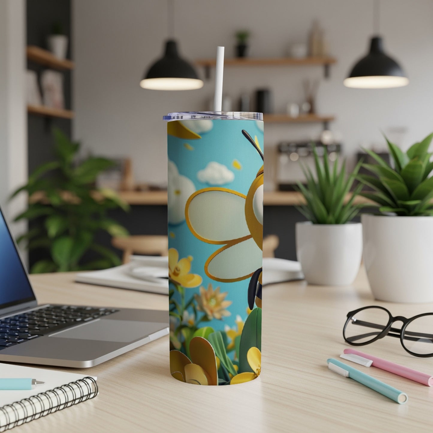 Tall tumbler with a cartoon bee and floral design, with a straw.