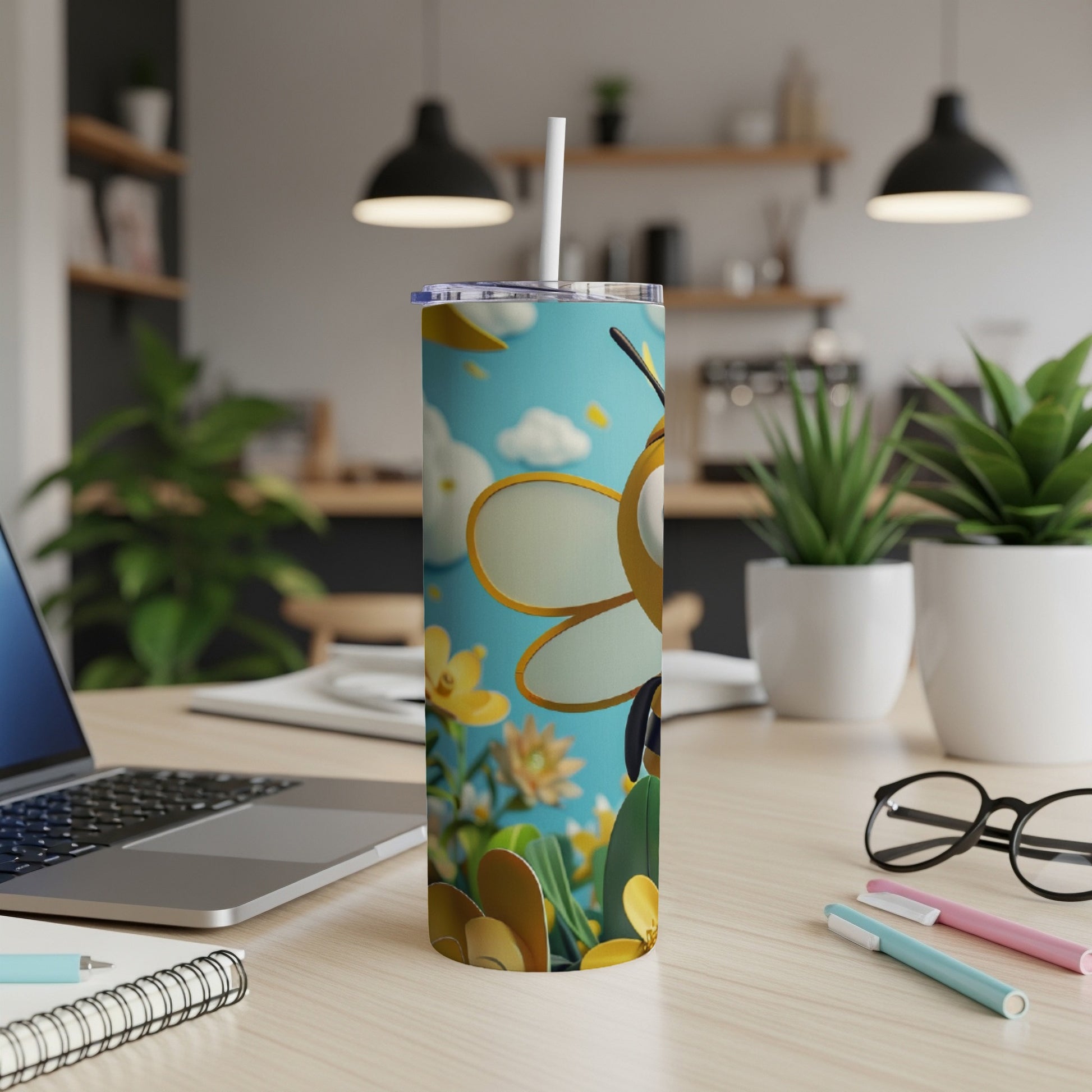 Tall tumbler with a cartoon bee and floral design, with a straw.