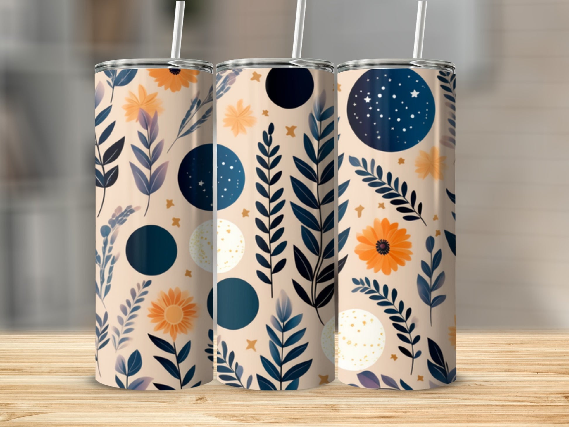 Three tumblers with a celestial floral pattern on a wooden surface.