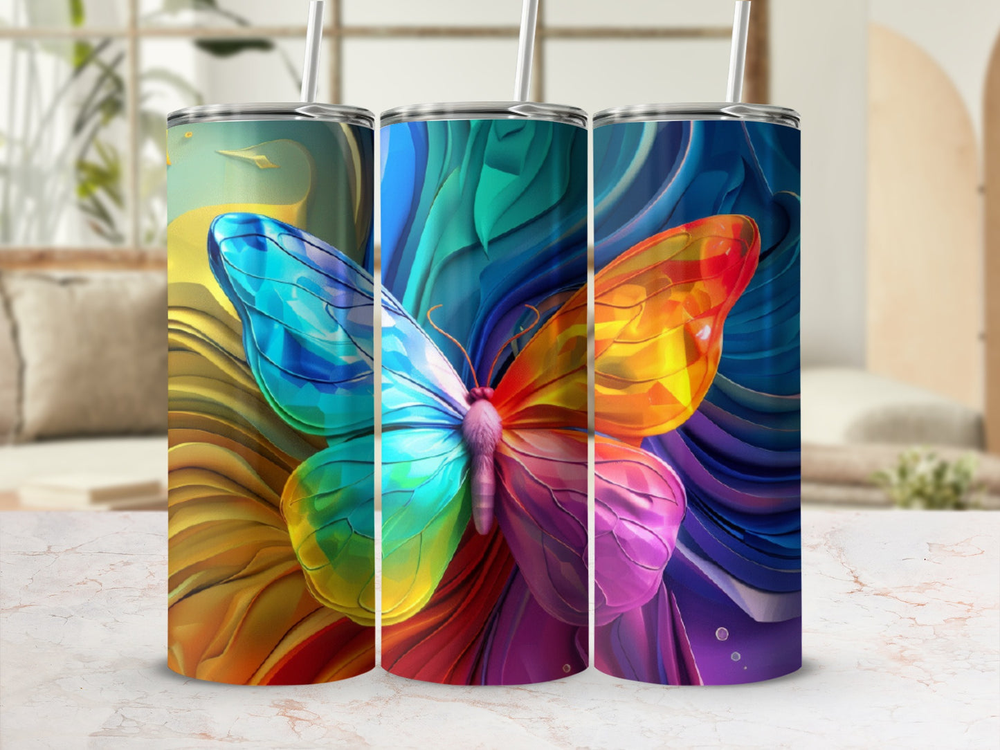 Three tumblers featuring a colorful butterfly design on a speckled marble surface.