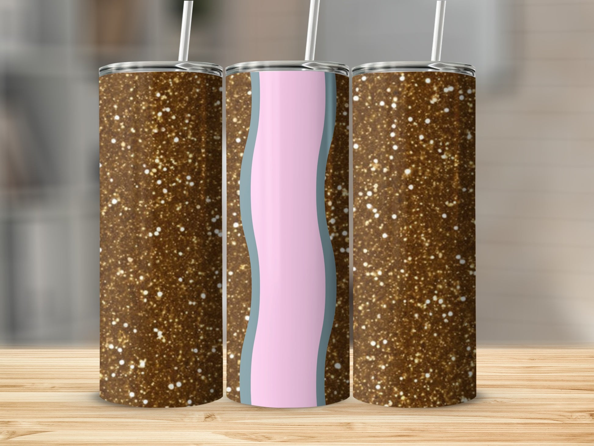Three glitter tumblers with wavy pink and blue design on a wooden surface.