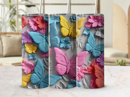 Three tumblers with colorful butterflies and floral designs.