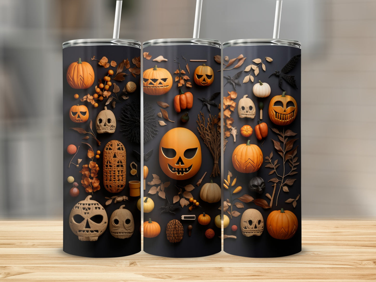 Three tumblers with a Halloween pattern of pumpkins, skulls, bats, and leaves.