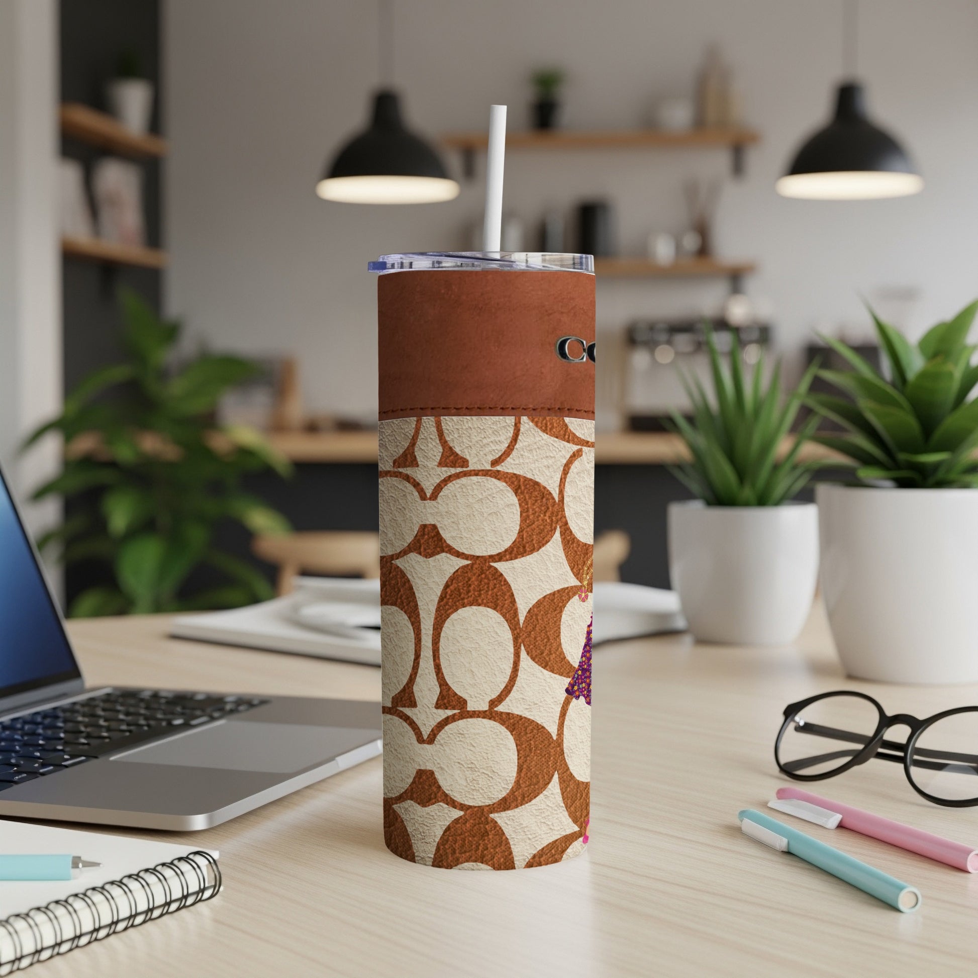 Coach branded insulated tumbler with signature C pattern and brown accents.