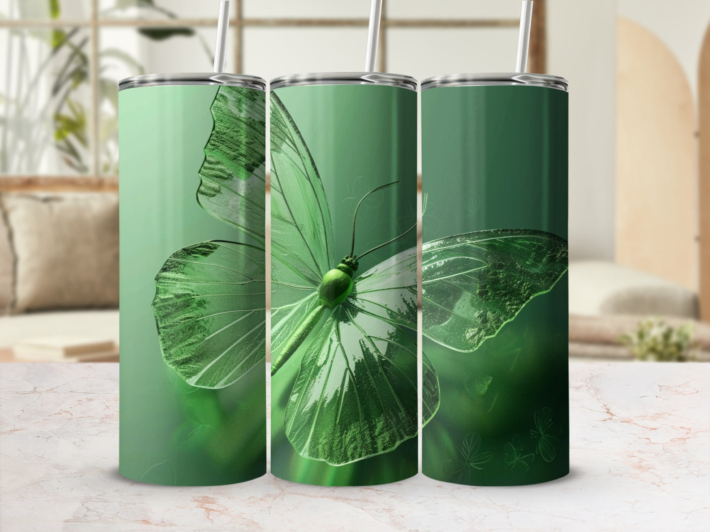 Green butterfly design on three tumblers in a blurred background.