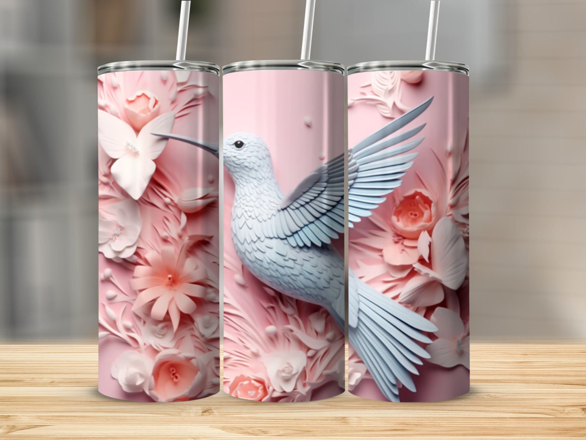 Three pink tumblers featuring a white hummingbird and floral designs.