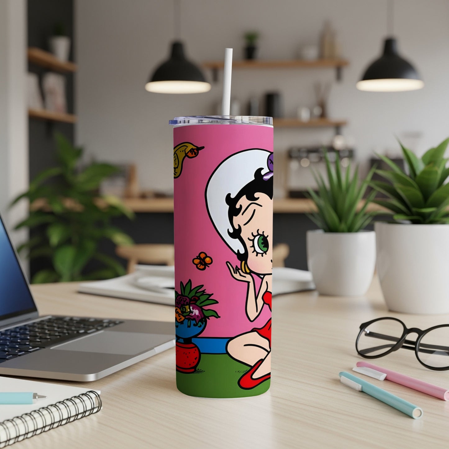 Betty Boop cartoon character on a pink tumbler with a white lid and straw.