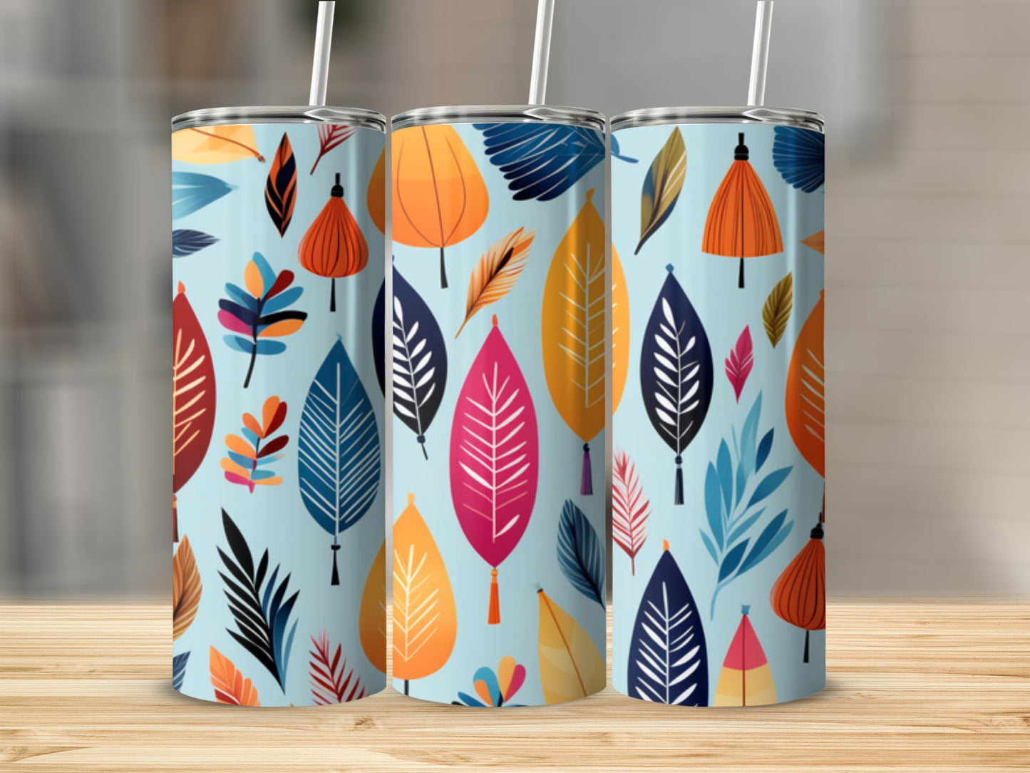 Three tumblers with a repeating pattern of colorful stylized leaves on a light blue background.