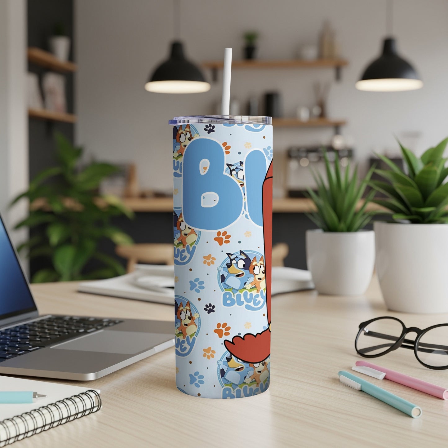 Bluey cartoon tumbler with straw on a desk.