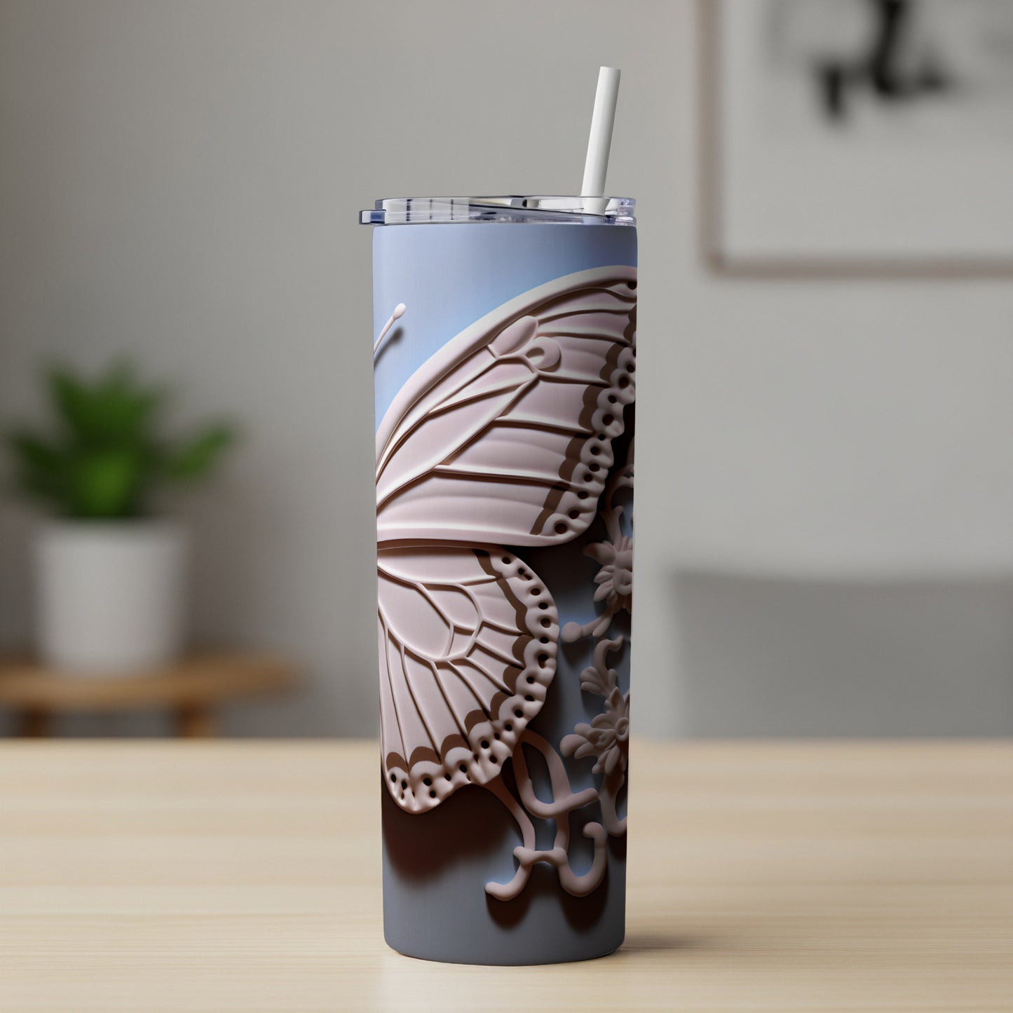 Gray tumbler with a pink butterfly wing design and straw.