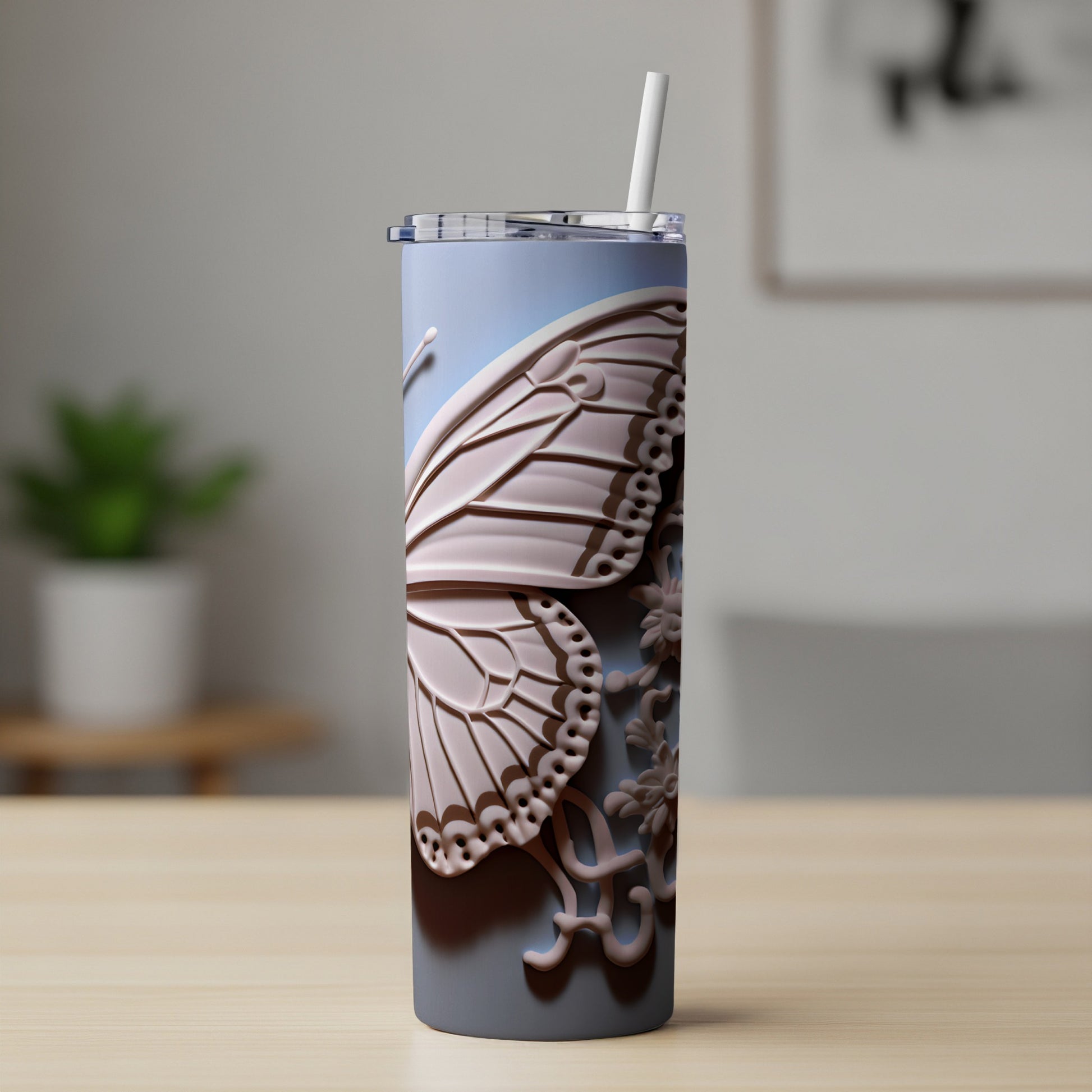 Gray tumbler with a pink butterfly wing design and straw.
