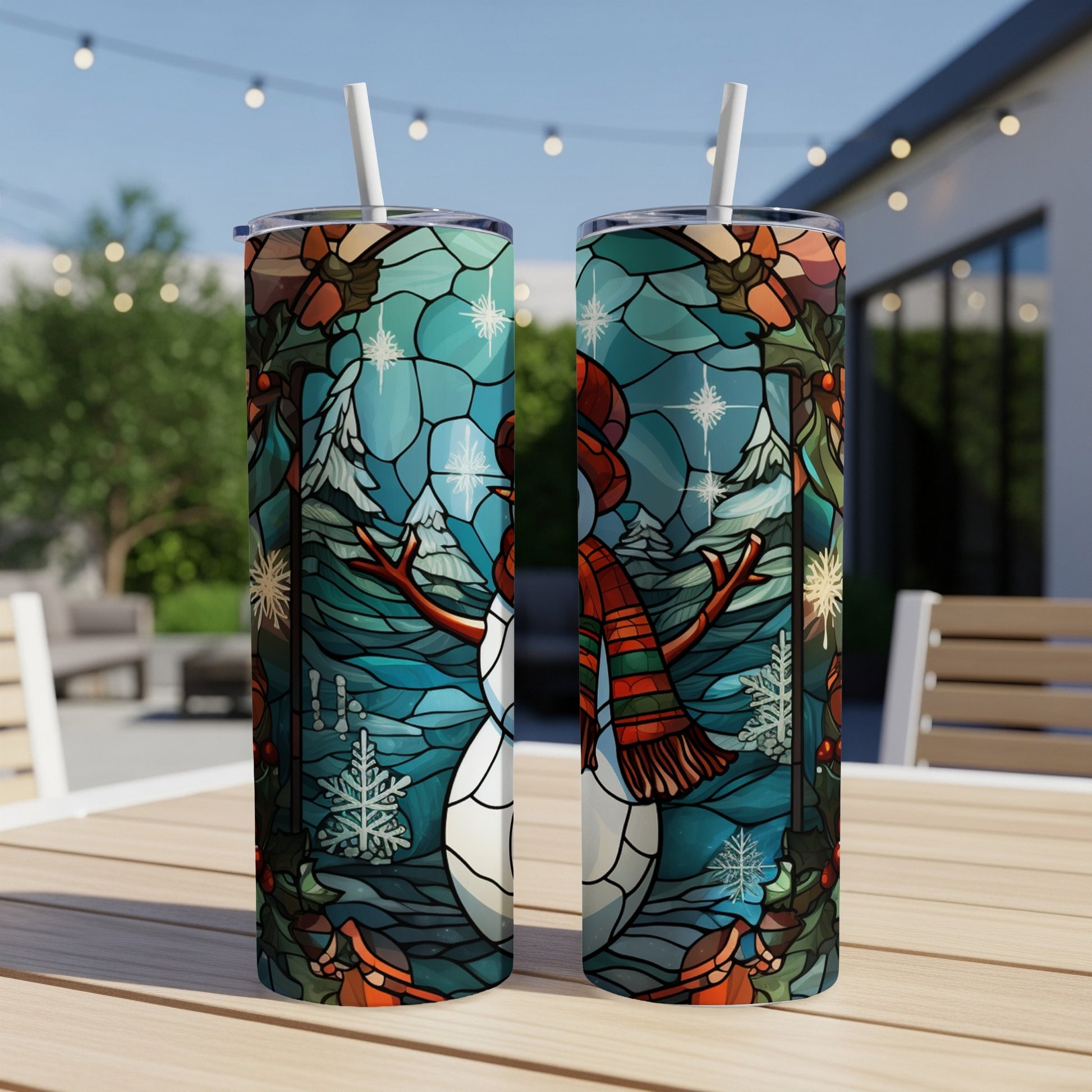 Two tumblers with stained glass snowman, mountains, and snowflakes design.
