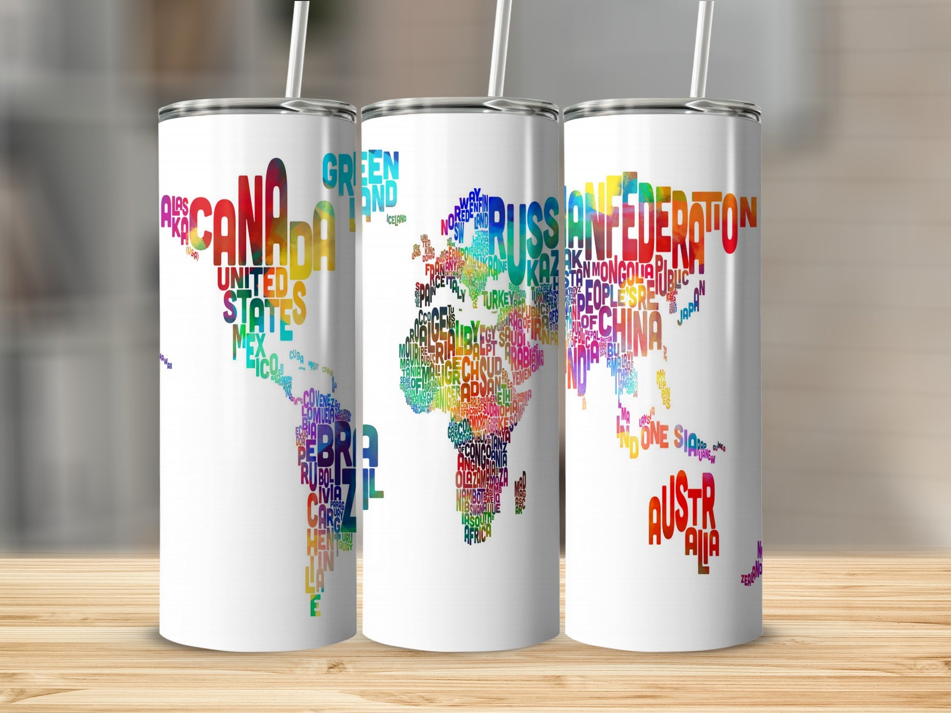 White tumblers with world map designs made of country names in colorful text.
