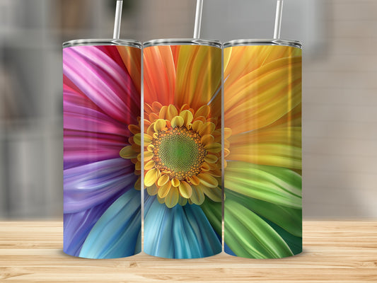 Three tall tumblers with colorful floral designs on a wooden surface.