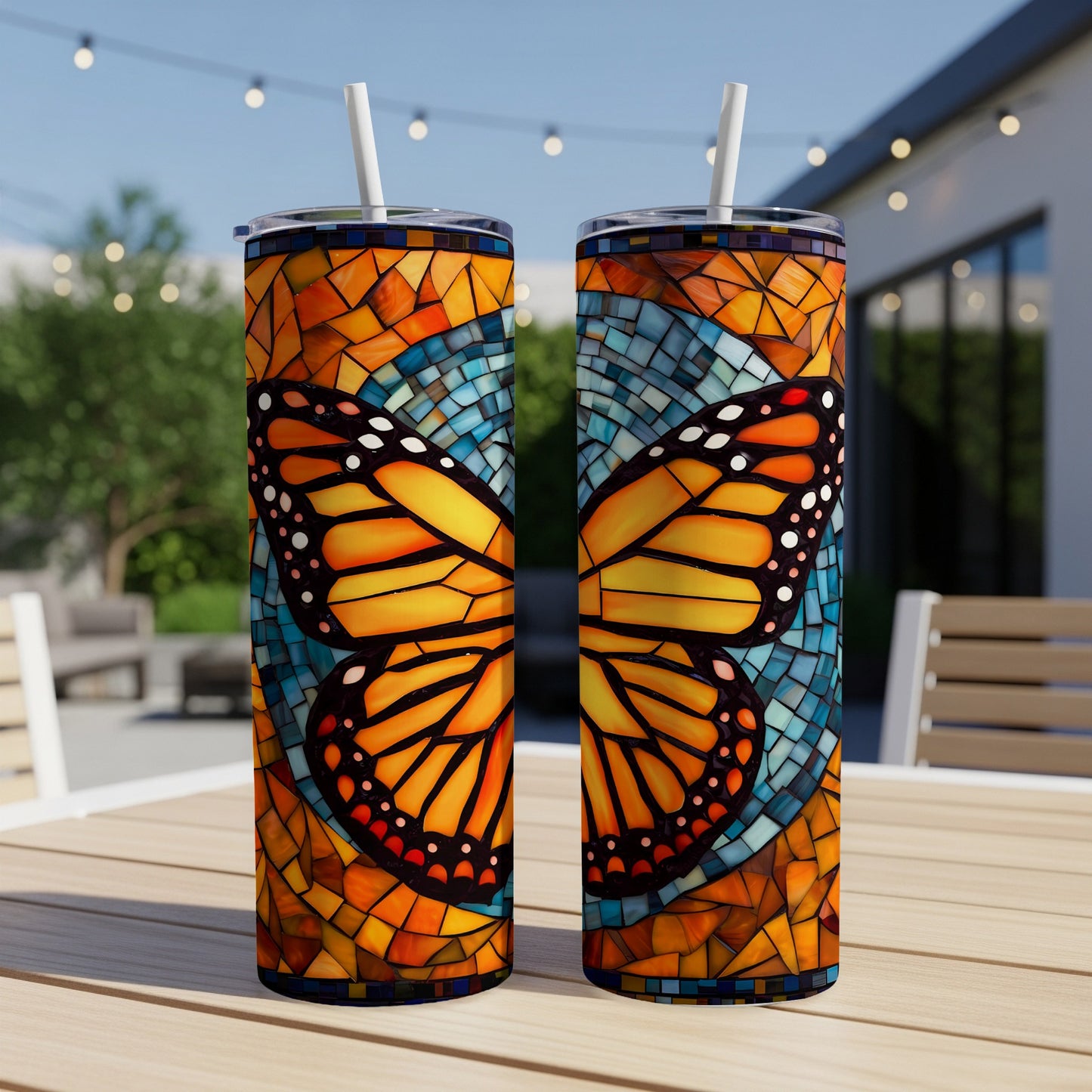 Two tall tumblers with monarch butterfly mosaic design, with straws.