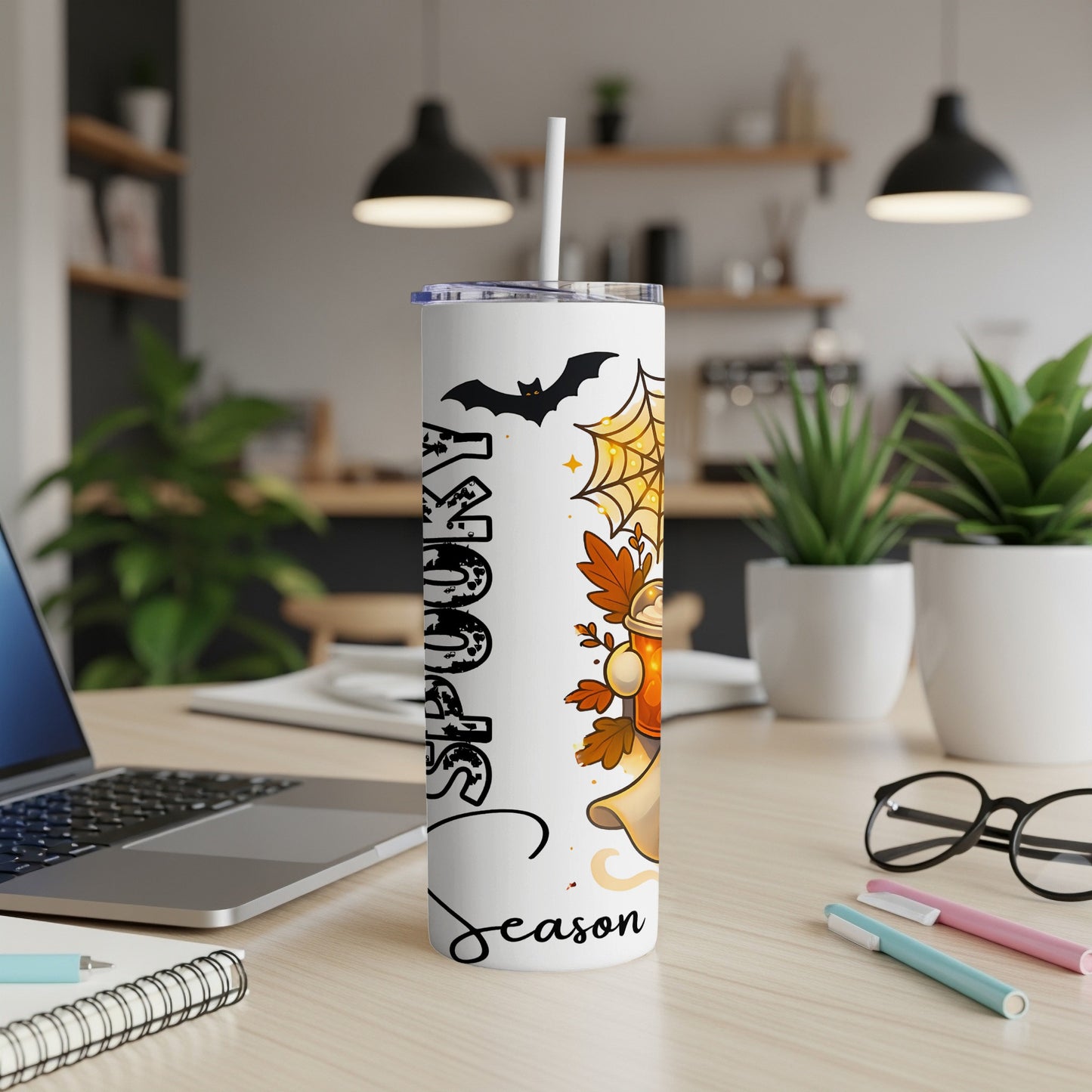 White tumbler with Halloween design featuring a bat, spiderweb, and ghost with text "Spooky Season".