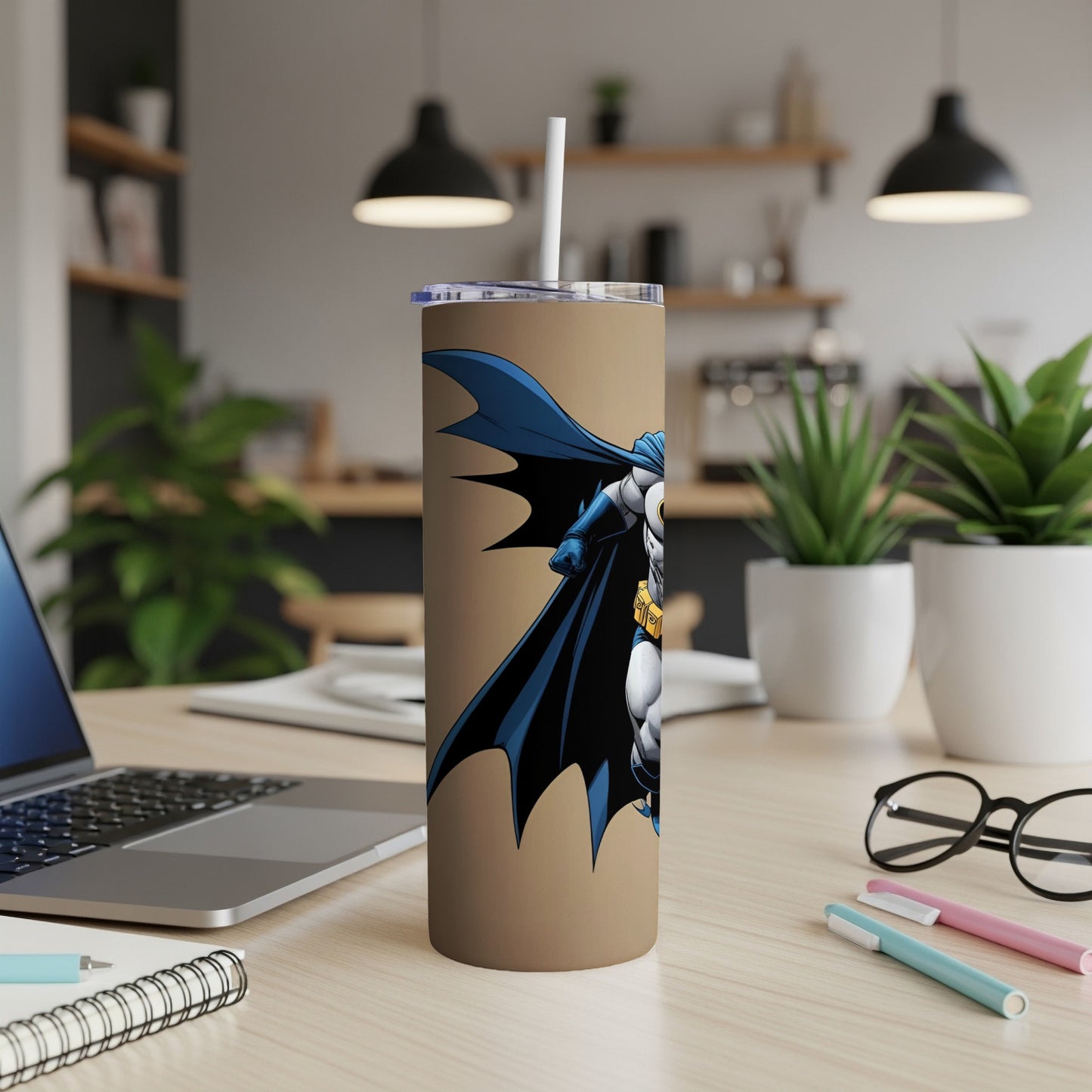 Batman tumbler with white straw on a desk.