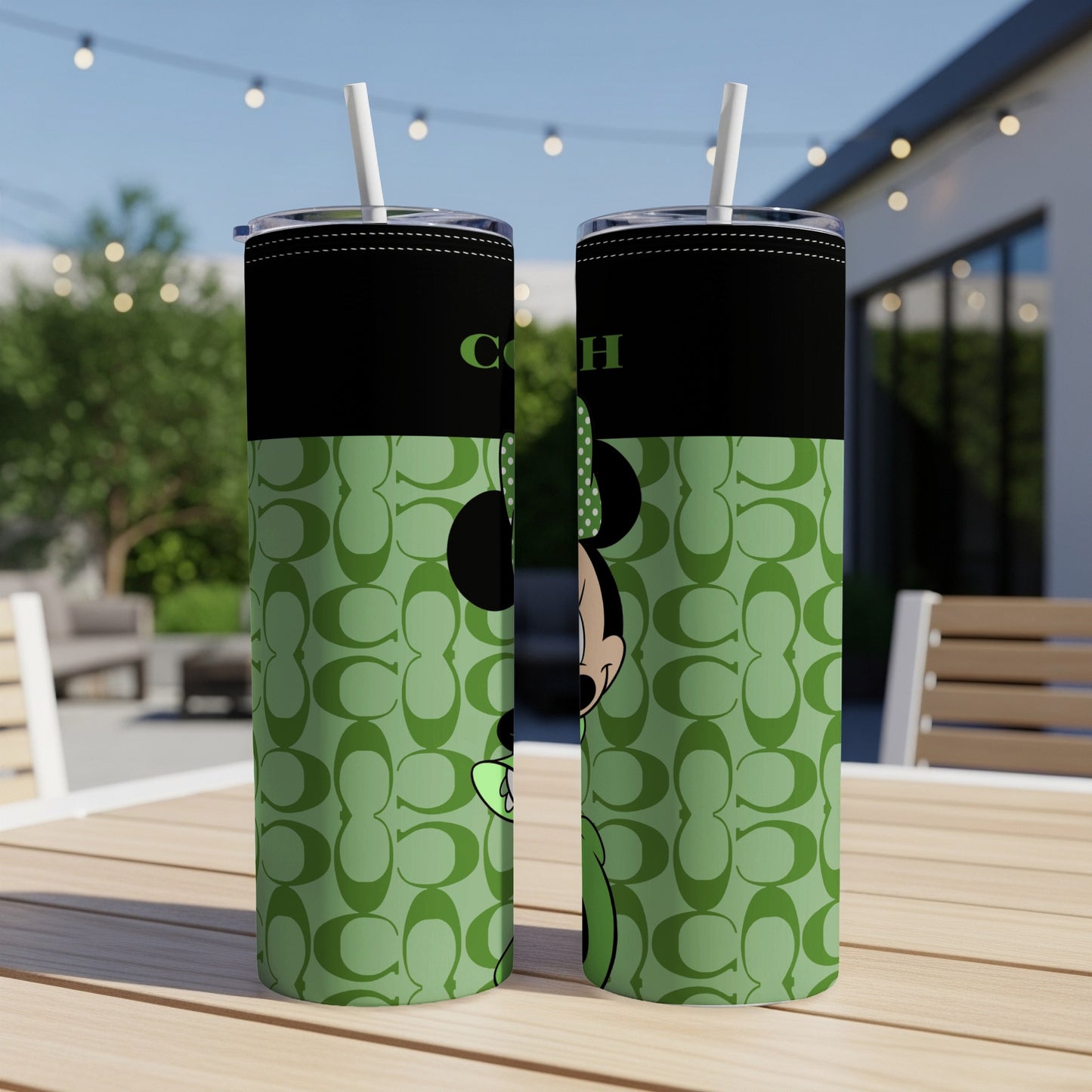 Two black tumblers with Minnie Mouse and a Coach logo on a green pattern.