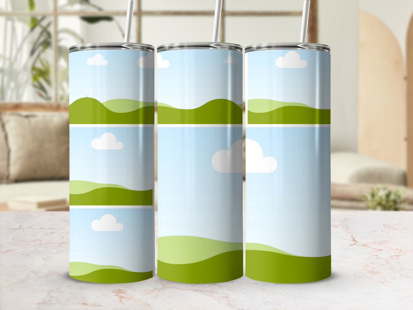 Three tumblers with a cartoon landscape design of green hills and blue sky.