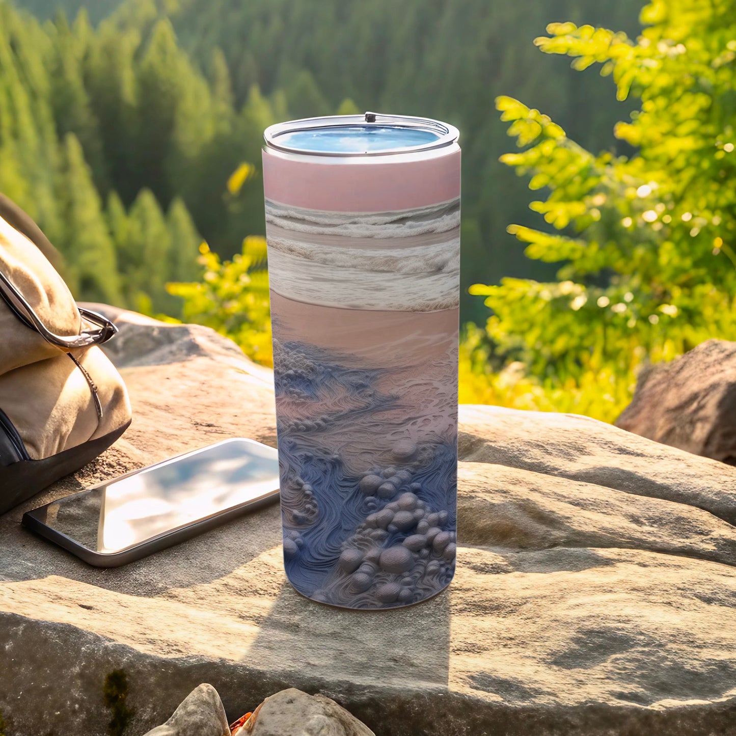 Tumbler with abstract ocean wave design, resting on rocks with a backpack and phone.