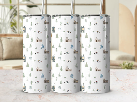 Winter village scene on a white tumbler with trees, houses, and people.