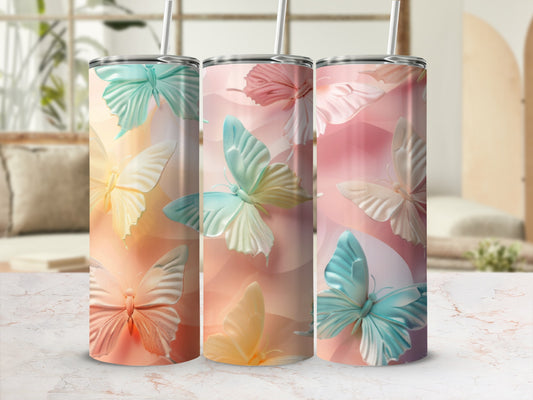 Three tumblers with pastel butterflies on a marble surface.