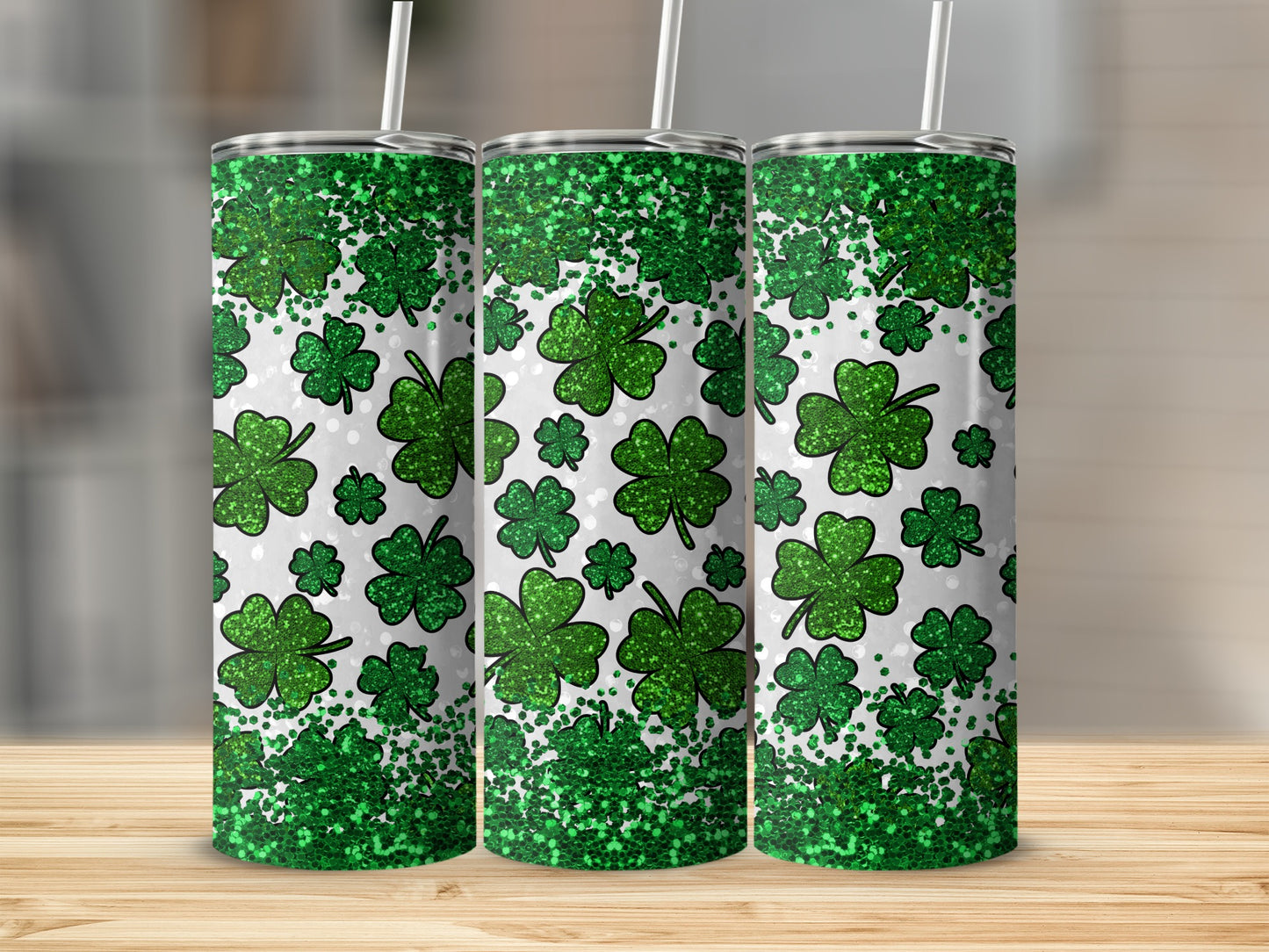 Three green glitter shamrock print tumblers with white straws.