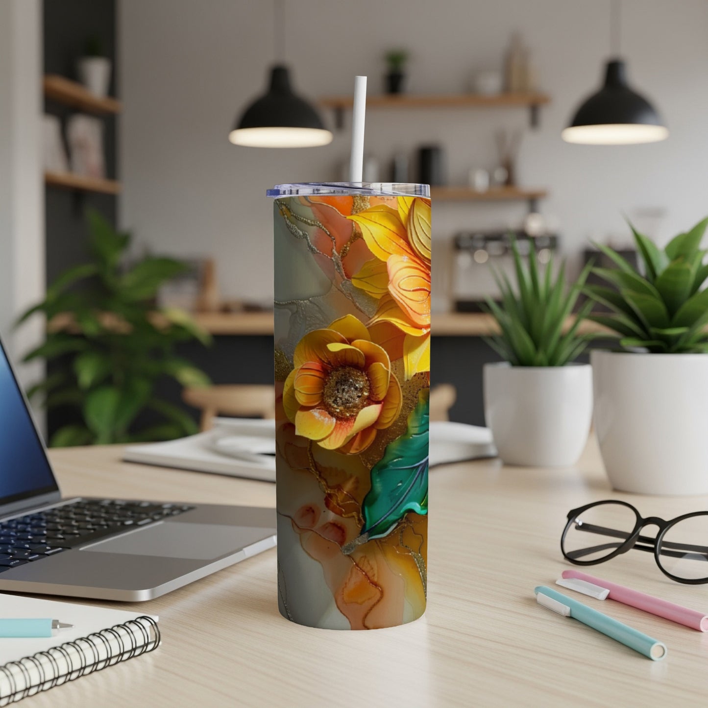 Tall tumbler with a colorful floral design on a desk.