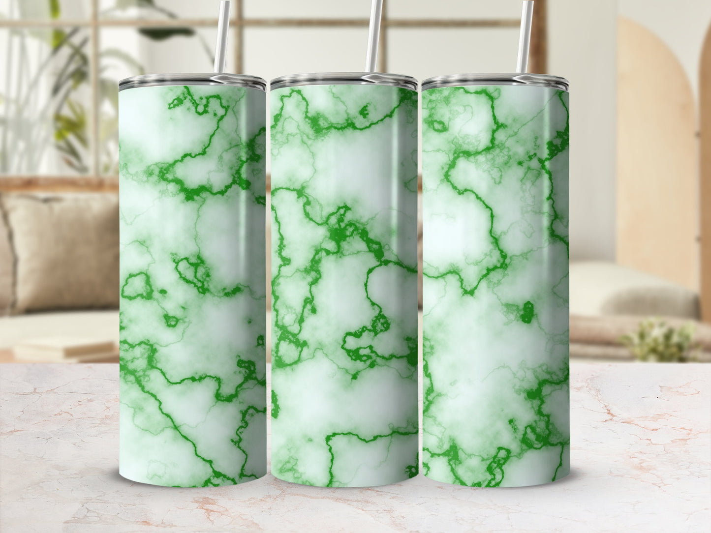 Three green marble pattern tumblers with straws on a white marble surface.